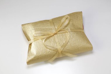 beyaz arkaplanda paketlenmiş altın hediye.