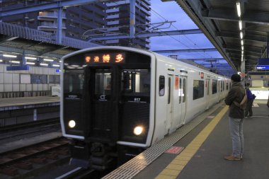 Bekleyen yolcularla dolu şehir demiryolu platformu