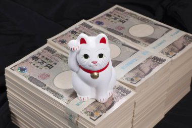 Japon yen banknotları ve Maneki-neko kedisi, şans ve zenginliği simgeliyor.