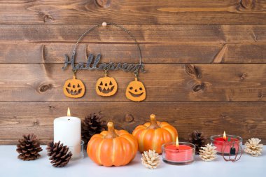 Cadılar bayramı kompozisyonu kabak ve yanan mumlar ile ahşap yüzeyde            