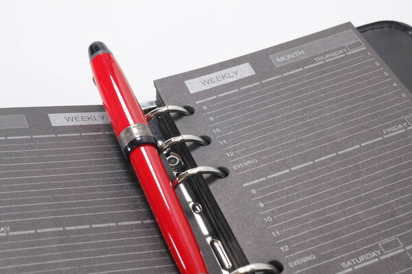  кожаный блокнот с ручкой на белом фоне, закрыть