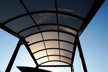 Açık mavi gökyüzüne karşı modern gölgeliğin silueti