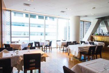 Ahşap döşemeleri olan güneşli, modern bir restoran.