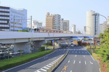 Modern mimarisi ve binaları trafikte olan Tokyo şehir caddesi.