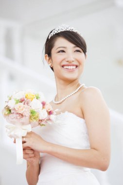 Gelinlik içinde buketli güzel Japon gelin.