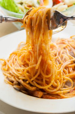 Masada çatal kullanarak makarna çeviriyorum.