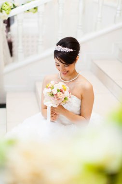 Güzel mutlu genç gelinin portresi düğün buketi tutuyor.