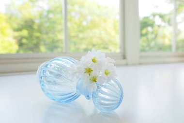 Güzel beyaz çiçekleri ve mavi cam süslemeleri olan kompozisyon