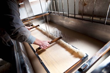 Geleneksel el yapımı kağıt çarşafları ustalıkla yapan kişi