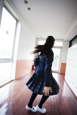 Okul koridorunda dolap çeviren kız.