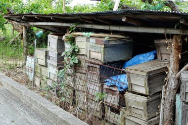 Dışarıdaki kırsal barınağın altında istiflenmiş ahşap sandıklar.