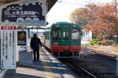 Tren istasyonunda tren bekleyen bir adam var.