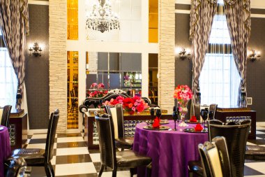 Düğün ortamında servis edilen masaları ve çiçekleri olan güzel bir restoran.                        