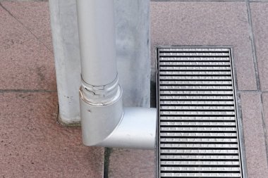 Gri beton yüzeyin yanındaki metal gideri.