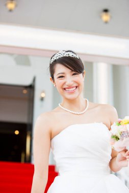 Gelinlik içinde buketli güzel Japon gelin.