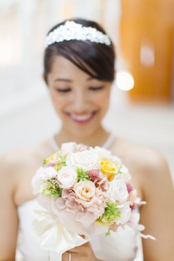 Güzel mutlu genç gelinin portresi düğün buketi tutuyor.