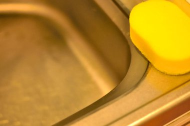 Lavaboda sarı sünger var. Yakın çekim görüntüsü.