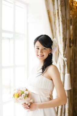 Gelinlik içinde buketli güzel Japon gelin.