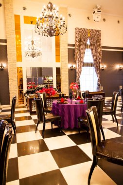 Düğün ortamında servis edilen masaları ve çiçekleri olan güzel bir restoran.                        