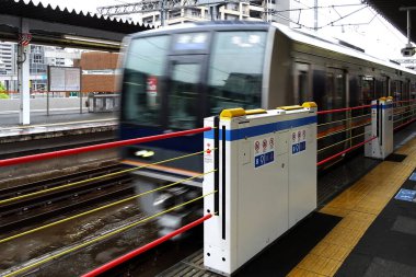 Ticari binalar, Japon demiryolu üst geçidinin büyük, beton tabanına yakındır..