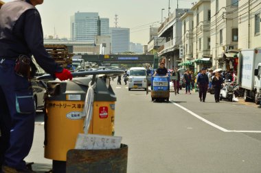 Tokyo, Japonya 'daki Tsukiji Açık Hava Pazarı' na mal taşıyan elektrikli bir arabada çalışanlar..