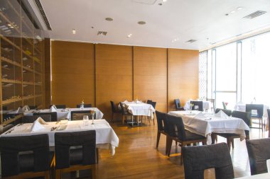 Restoranın içinde boş masalar ve sandalyeler. 