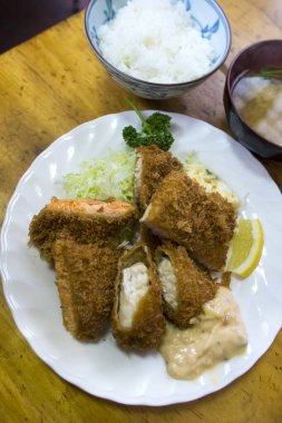 Lezzetli kızarmış balık yemeğinin tadını çıkarıyor.