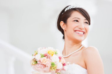 Gelinlik içinde buketli güzel Japon gelin.