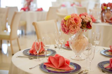 Düğün ortamında servis edilen masaları ve çiçekleri olan güzel bir restoran.                        