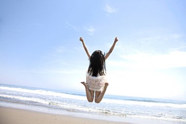 Güneşli bir günde deniz kıyısında mutlu Asyalı kadın portresi