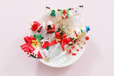 Işık arka planında beyaz tabakta Noel süslerinin üst görünümü           