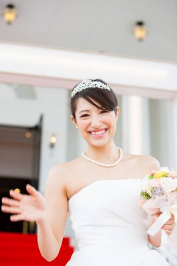 Gelinlik içinde buketli güzel Japon gelin.