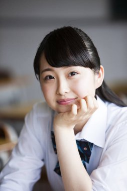 Asyalı okul öğrencisinin üniformalı portresi.