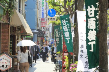 Tokyo, Japonya 'da insanlar caddenin ortasında yavaşça yürüyorlar..