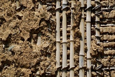 Bambu ve çamur malzemelerinden yapılmış desenli bir duvar.