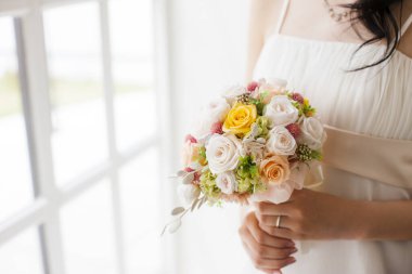 Gelinin ellerinde güzel bir buket çiçek       