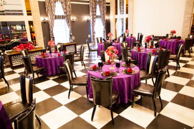 Düğün ortamında servis edilen masaları ve çiçekleri olan güzel bir restoran.                        