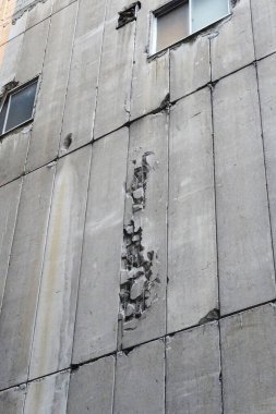 Çatlakları ve eksik kısımları gösteren hasarlı beton duvar