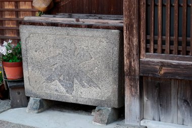 Dekoratif taş levha ahşap bina girişinin yanına yerleştirilmiş.