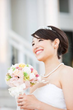 Gelinlik içinde buketli güzel Japon gelin.