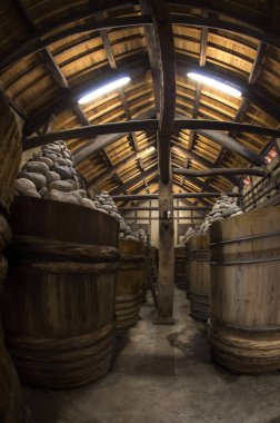 Geleneksel Japon miso fabrikasının tepesinde kayalar olan büyük ahşap tanklar Aichi Bölgesi, Japonya 'daki Kakukyu Hatcho Miso Köyü.