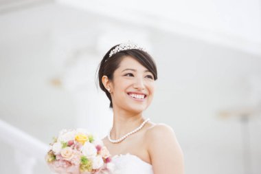 Gelinlik içinde buketli güzel Japon gelin.