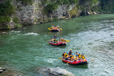 İnsanlar Rapid Mountain nehrinde rafting yapıyor, rafting yapıyorlar.                 
