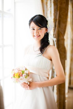 Gelinlik içinde buketli güzel Japon gelin.