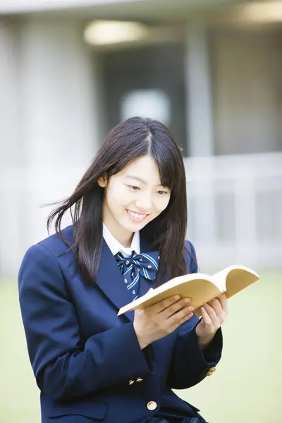 身穿制服的亚洲女学生肖像读物 — 图库照片