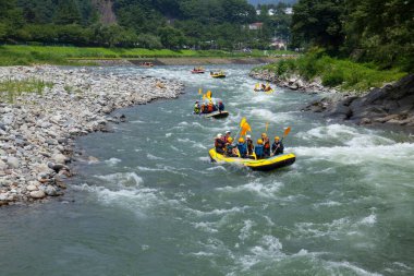 İnsanlar Rapid Mountain nehrinde rafting yapıyor, rafting yapıyorlar.                 