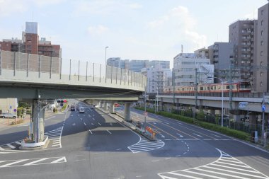 Yansımalar ve keskin kenarlar güneş ışığıyla aydınlanan Japon metropolünün güçlü bir geometrik görüntüsünü oluşturur..