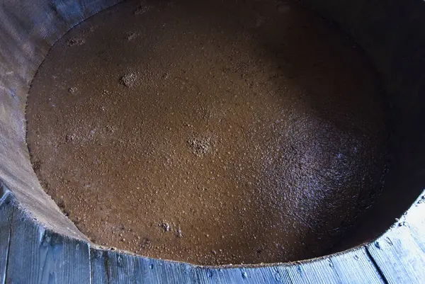 Bir kabın içindeki Islak Kahverengi Granüler Toz 'un Yakın Görüntüsü