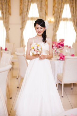 Gelinlik içinde buketli güzel Japon gelin.