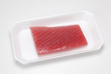 Beyaz kabın üzerinde pişmemiş ton balığı filetosu